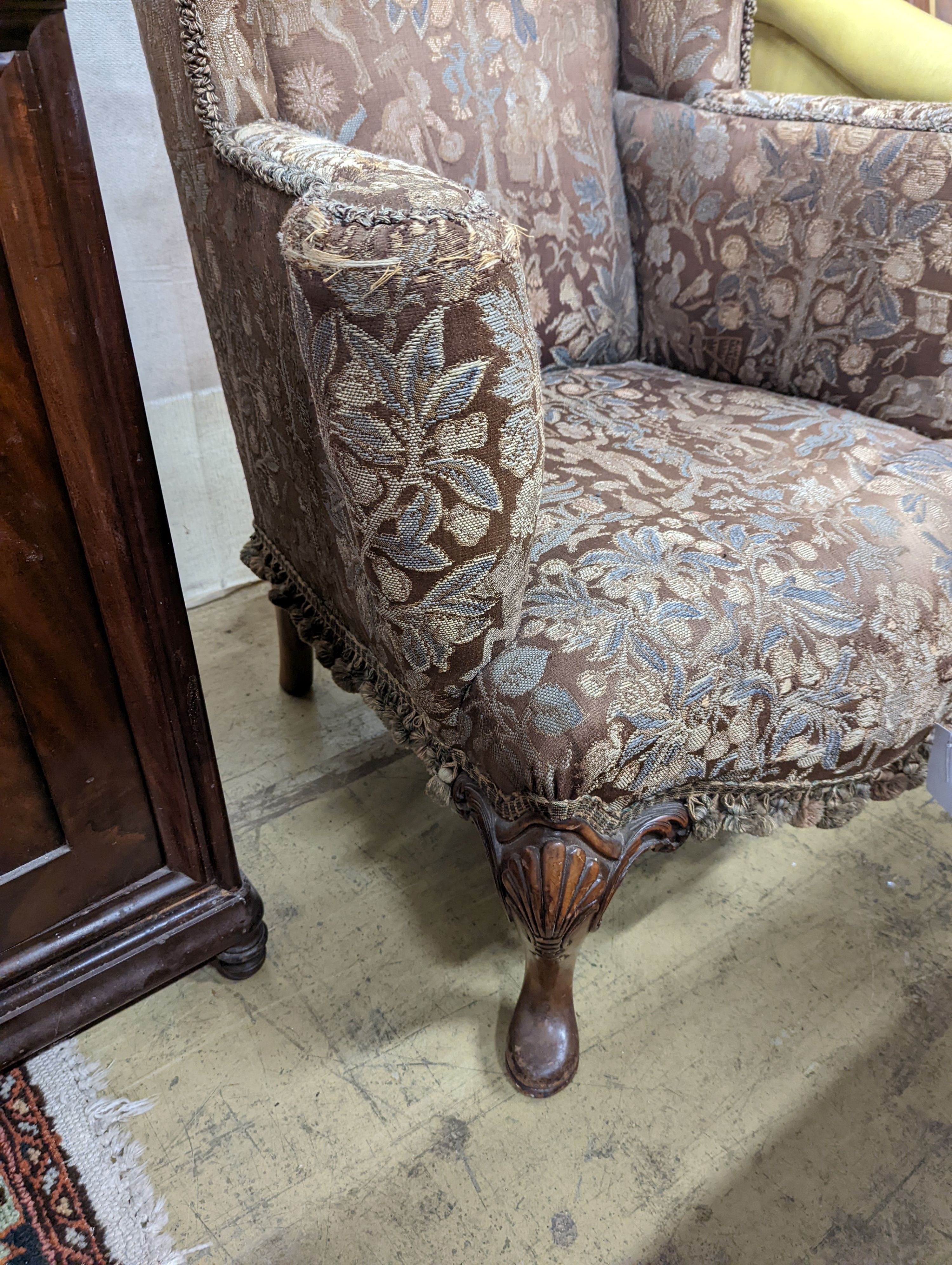 A Queen Anne revival upholstered walnut wing armchair, width 78cm, depth 78cm, height 96cm